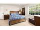 Bedroom featuring a bed with a blue quilt, a nightstand, and a large sunny window at 3430 Laurel Dr, Mount Dora, FL 32757