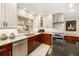 Well-equipped kitchen with modern stainless appliances, granite counters and sink below a bright window at 3430 Laurel Dr, Mount Dora, FL 32757