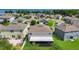 Aerial view of a home's backyard, showcasing lawn and neighborhood with lake in background at 3441 Landing Vw, Tavares, FL 32778