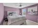Bedroom with light purple walls, ceiling fan and a large window at 3441 Landing Vw, Tavares, FL 32778