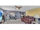 A cozy Gathering room with a leather sofa, ceiling fan, and access to other rooms at 3441 Landing Vw, Tavares, FL 32778