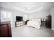 Spacious bedroom with a trey ceiling, tiled floors, and natural light from the windows at 3532 Thorne Path, Oxford, FL 34484