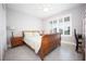 Bright bedroom with a wood sleigh bed, neutral walls, tile flooring, and plantation shutters for a serene retreat at 3532 Thorne Path, Oxford, FL 34484