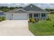 Charming home featuring a well-manicured lawn and a convenient two-car garage at 3532 Thorne Path, Oxford, FL 34484