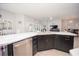 Modern kitchen island featuring marble countertops, stainless steel appliances, and dark cabinets at 3532 Thorne Path, Oxford, FL 34484