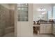 Modern bathroom with glass block window, tiled shower, and granite vanity at 3537 Cluster Ct, The Villages, FL 32163