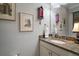 Bathroom featuring granite countertops, a decorative mirror, and neutral paint at 3537 Cluster Ct, The Villages, FL 32163