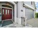Elegant entryway with a red front door, lantern-style lighting, and a paved walkway to the driveway at 3537 Cluster Ct, The Villages, FL 32163