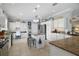 Bright, airy kitchen with stainless appliances, granite counters, an island, and ample white cabinetry at 3537 Cluster Ct, The Villages, FL 32163