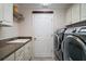 Functional laundry room with granite countertops, cabinets and modern washer and dryer at 3537 Cluster Ct, The Villages, FL 32163