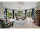 Bright living room with curved windows, tiled floor, and wicker furniture at 3537 Cluster Ct, The Villages, FL 32163