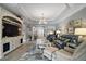 Comfortable living room with tray ceilings, a chandelier, and a view of the home's entryway at 3537 Cluster Ct, The Villages, FL 32163