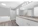 Bathroom with a double vanity, granite counters, soaking tub, and walk-in shower at 36700 Oconee Ave, Eustis, FL 32736