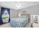 Bedroom features natural lighting, a ceiling fan, and colorful bedding at 36700 Oconee Ave, Eustis, FL 32736