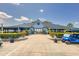 Clubhouse exterior featuring a covered porch, lush landscaping, and golf cart parking at 36700 Oconee Ave, Eustis, FL 32736