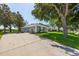 Charming single-story home featuring a well-manicured lawn, mature trees, and a lengthy concrete driveway at 36700 Oconee Ave, Eustis, FL 32736