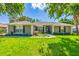 Charming single-story home with a well-manicured lawn and colorful landscaping around the entrance at 36700 Oconee Ave, Eustis, FL 32736