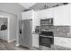 Bright kitchen with white cabinets, stainless steel appliances, and granite countertops at 36700 Oconee Ave, Eustis, FL 32736