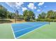 Well-maintained tennis court with vibrant blue and green surface, perfect for recreational and competitive play at 36700 Oconee Ave, Eustis, FL 32736