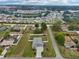 Overhead shot of the house in a neighborhood surrounded by lush greenery and various homes at 395 S Dixie Dr, Howey In The Hills, FL 34737