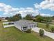Aerial view of home featuring a well-manicured lawn, long driveway, two car garage and a cozy front porch at 395 S Dixie Dr, Howey In The Hills, FL 34737