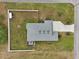 Bird's eye view shows the roofline, landscaping, driveway, and white fence surrounding the property at 395 S Dixie Dr, Howey In The Hills, FL 34737