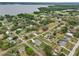 An aerial landscape of several neighborhood homes near a large lake or body of water surrounded by lush forests at 395 S Dixie Dr, Howey In The Hills, FL 34737