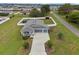 This aerial view displays a long driveway leading to a two-car garage, a cozy front porch, and a well-kept lawn at 395 S Dixie Dr, Howey In The Hills, FL 34737
