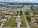 Overhead shot of the house in a neighborhood surrounded by lush greenery and various homes at 395 S Dixie Dr, Howey In The Hills, FL 34737