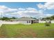 View of the backyard with green lawn, white fence, screened porch, and exterior of this lovely single Gathering home at 395 S Dixie Dr, Howey In The Hills, FL 34737