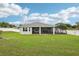 Green backyard showcasing a screened patio area attached to a single-story home at 395 S Dixie Dr, Howey In The Hills, FL 34737
