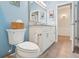 Bathroom showcasing blue walls, gray tile floors, and white toilet at 395 S Dixie Dr, Howey In The Hills, FL 34737