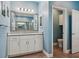 Bathroom featuring white vanity with granite countertop, blue walls and view into toilet room at 395 S Dixie Dr, Howey In The Hills, FL 34737