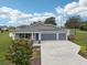 Charming single-story home with a three-car garage, well-manicured lawn, and gray accents at 395 S Dixie Dr, Howey In The Hills, FL 34737