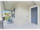 Inviting front porch featuring a blue front door, rocking chairs, and stone-accented columns at 395 S Dixie Dr, Howey In The Hills, FL 34737