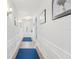 Bright hallway featuring wainscoting, modern lighting, and a decorative blue runner at 395 S Dixie Dr, Howey In The Hills, FL 34737