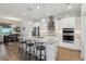 Stylish kitchen featuring a granite island with seating, modern lighting, and stainless steel appliances, perfect for entertaining at 395 S Dixie Dr, Howey In The Hills, FL 34737