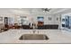 Open-concept kitchen and living area with granite counters, sink, and living area with tv at 395 S Dixie Dr, Howey In The Hills, FL 34737