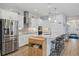 Bright kitchen featuring a stainless steel refrigerator, white cabinets, and a center island with a breakfast bar at 395 S Dixie Dr, Howey In The Hills, FL 34737