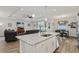 Open-concept kitchen and living area, showcasing a granite kitchen island and access to outdoor space at 395 S Dixie Dr, Howey In The Hills, FL 34737