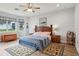 Main bedroom featuring wood floors, a ceiling fan, and two rugs at 395 S Dixie Dr, Howey In The Hills, FL 34737