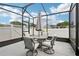 Screened patio with outdoor dining set and neutral cushions, ideal for entertaining at 395 S Dixie Dr, Howey In The Hills, FL 34737