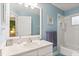Bright bathroom with vanity, sink, tub, and shower featuring blue accents at 4087 Capland Ave, Clermont, FL 34711