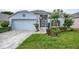 Charming single-story home with a well-manicured lawn, paved walkway, and attached two-car garage at 4087 Capland Ave, Clermont, FL 34711