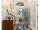 Open foyer with an entry door with decorative glass, tile floor, and a decorative cabinet at 4087 Capland Ave, Clermont, FL 34711