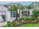 Charming home featuring beautiful landscaping with palm trees, flowers, and an American flag at 4087 Capland Ave, Clermont, FL 34711