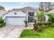 Charming single-story home with a well-manicured lawn, a two-car garage, and beautiful landscaping at 4087 Capland Ave, Clermont, FL 34711