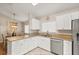 Kitchen with white cabinetry, stainless steel appliances, granite countertops, and tile flooring at 4087 Capland Ave, Clermont, FL 34711