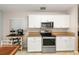Well-equipped kitchen with stainless steel appliances, white cabinets, and granite countertops at 4087 Capland Ave, Clermont, FL 34711