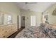 Bright main bedroom featuring a ceiling fan, en-suite bath, and view to additional bedroom at 4087 Capland Ave, Clermont, FL 34711